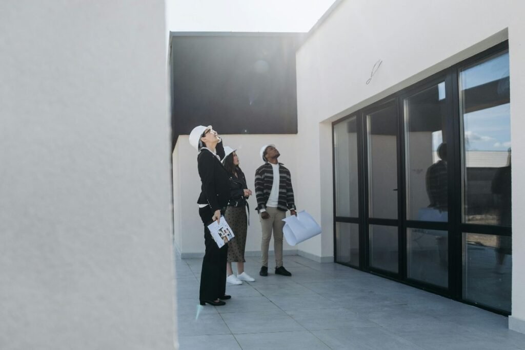 clients and real estate agent looking at a roof of a house for sale