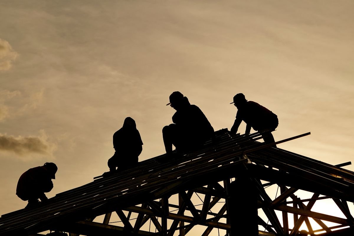Contractor in silhouette working on a roof 