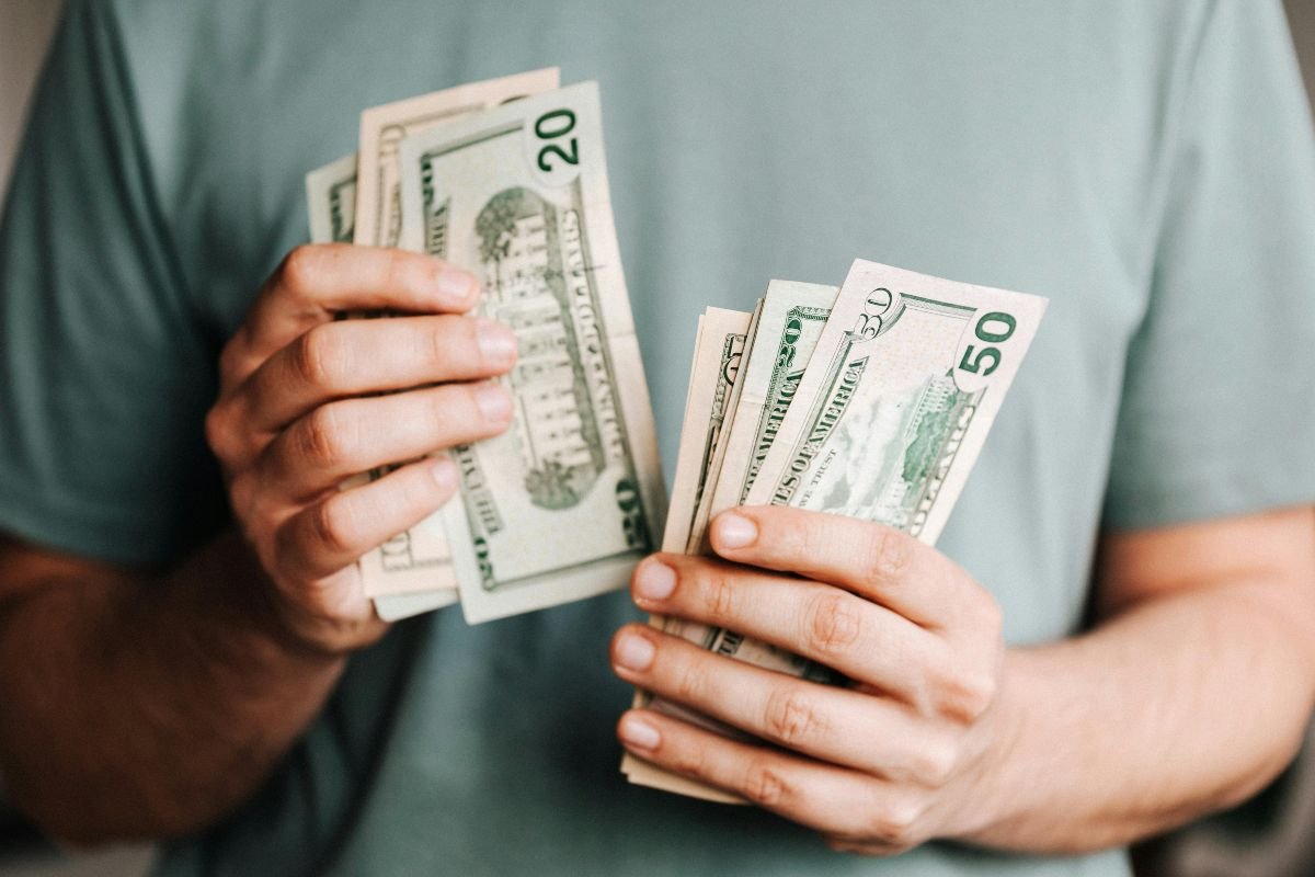 a person counting dollar bills for payment